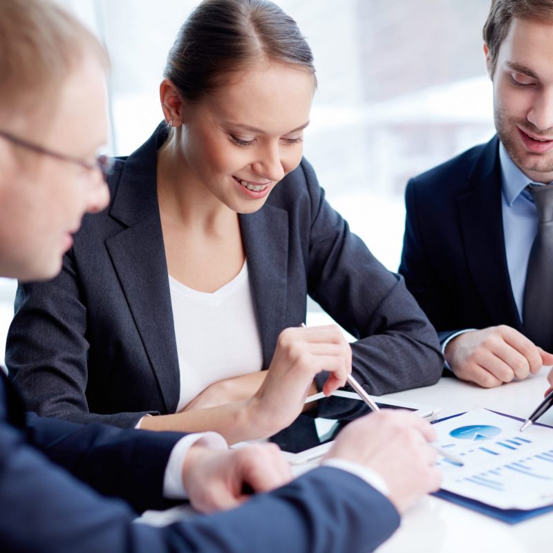 Confident business people discussing financial document at meeting